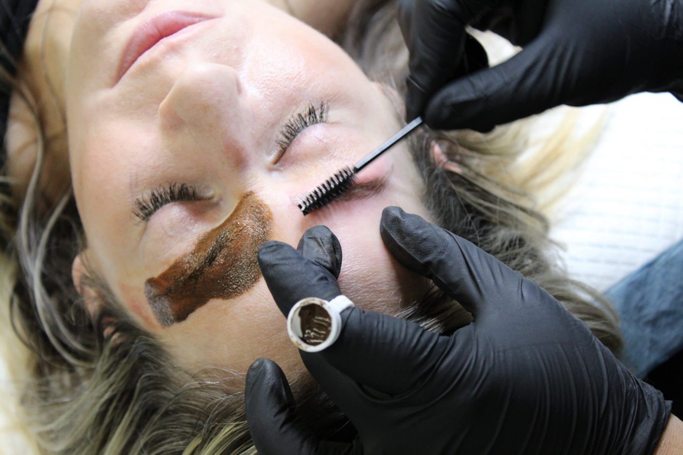 women getting her eyebrows brushed after microblading strokes also known as permanentmakeup